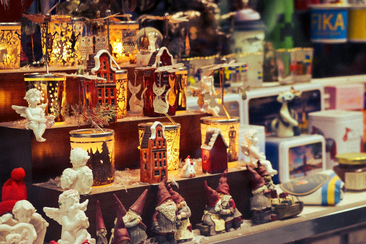 Holiday figurines and lanterns displayed on wooden shelves.
