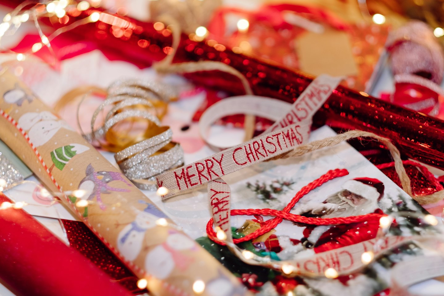 Christmas gift wrapping paper and ribbons on a table.